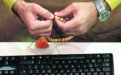 An investor holds his prayer beads as he follows the stock market activity at the Dubai Financial Market
