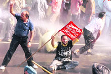 Agitating sugar mill workers from Punjab brave water cannons near Sector 16 Cricket Stadium in Chandigarh on Tuesday.