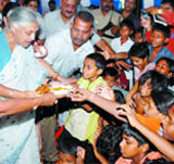 Delhi Chief Minister Sheila Dikshit distributes food among children after the inauguration of an Aap Ki Rasoi centre at Ambedkar Basti in New Delhi