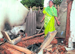 A woman stands helplessly in front of her house that was burnt during riots in violence-hit Kandhamal district of Orissa on Tuesday.