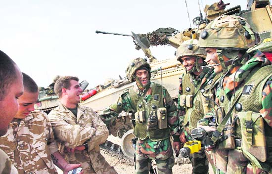 Warriors in arms: Indian soldiers (right) share a joke with their British counterparts beside armoured fighting vehicles during a joint training exercise with the British Army at Copehill Down military training village on Salisbury Plain on Wednesday. For the first time in 60 years, soldiers from the Indian Army are training with British troops in a major military exercise. Nearly 140 men from the Punjab-based Mechanised Infantry Battalion trained alongside 3rd Battalion, (Staffords) the Mercian Regiment. The Indian soldiers arrived at the end of August from their base in Batala and will remain in the UK for a month.