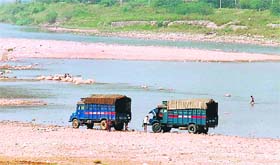 Despite clear restrictions to wash vehicles in the Tawi, two police trucks are being washed in the river