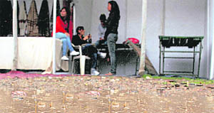 Heavy rain lashed certain parts of Shimla. The picture shows some students taking shelter to protect themselves from inclement weather in Shimla on Thursday.