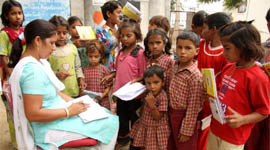 Students belonging to poor families get their classwork checked by the teacher, Swarna Devi. Tribune photo: Kulbir Beera