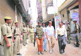 Policemen and security personnel stand guard after the encounter between the police and suspected militants in New Delhi