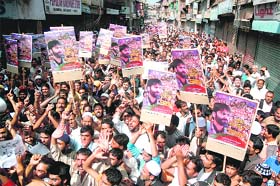 Kashmiris hold aloft placards carrying JKLF chairman Mohd Yaseen Maliks photographs during a protest after Friday prayers in Srinagar