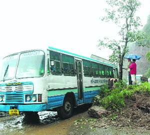 A bus has been stranded due to accumulated water and rocks which fell on a road due to landslides in Shimla on Sunday.