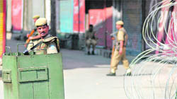 A CRPF jawan stands guard near closed shops during the strike call give by the separatists coordination committee in Srinagar
