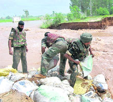 Armymen and civilians engaged in flood-control measures at Naggal village in Ambala district on Sunday. 