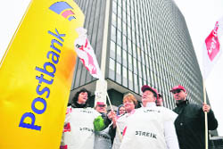 Employees of Germany's largest retail bank Postbank stage a protest called by union Ver.di in front of the Berlin headquarters of the bank on Monday to ask for higher wages