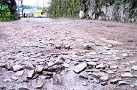 This picture shows a highly damaged road in Shimla.  Landslides have rendered many roads unmotorable in city and its surrounding areas.