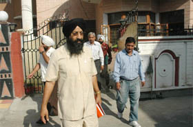 A labour department team comes out of the womans house after conducting a raid on Tuesday. 