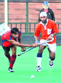 Players of the BSF and SC Railways try to snatch the ball during a match at Hockey Stadium, Sector 42, Chandigarh