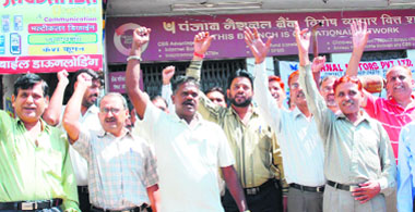 Bank employees raise slogans in support of their demands during their strike in Karnal on Wednesday. 