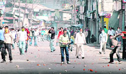 Protesters throw stones at policemen during a demonstration in Srinagar 