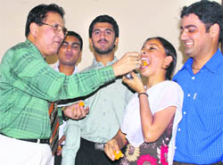 Prof R.C. Sobti offers sweets to the newly elected students’ council members after the oath-taking ceremony at Panjab University on Thursday.
