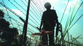 A BSF jawan guards the international border in Pargwal sector in Jammu on Saturday.