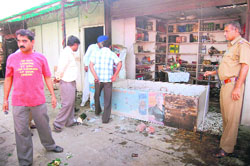 The police inspects a liqour vend that was vandalised by a mob at Darua village in Chandigarh on Sunday. 