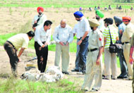 Senior police officers and bomb experts examine the spot where bombs (right) were found at Bhankarpur village, near Dera Bassi, on Sunday.