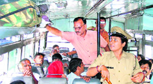 The police checks luggage of passengers in a bus after a bomb threat in Ambala on Sunday. 