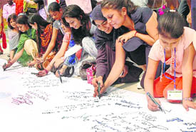 Peace delegates inscribe messages on 11 m-long scroll on the last day of the Peace festival at DAV College, in Chandigarh on Tuesday.