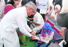Haryana Chief Minister Bhupinder Singh Hooda presents an award of Rs one lakh to 112-year-old Chhanno Devi from Bhiwani, for being Best Mother of a joint family with more than 100 members, on the occasion of the International Day for Elder Persons, in Panchkula on Wednesday