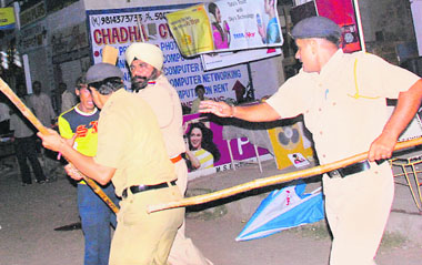 Policemen chase away a youth following a clash at Dadu Majra, Chandigarh, on Thursday.