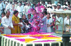 Activists and schoolchildren pay homage at the 139th birth anniversary celebrations of Mahatma Gandhi at Rajghat in New Delhi on Thursday.