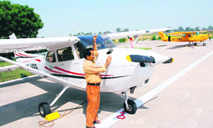 A worker checks the fuel position in a CESSNA aircraft at Naval Flying Club in Karnal.