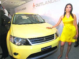 A model poses with Mitsubishis SUV Outlander at its launch in New Delhi on Friday. The SUV is priced at Rs 20.2 lakh 