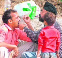 A man gets himself checked by a roadside quack in Jammu on Saturday.