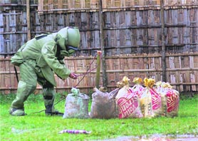 A personnel of the NSG bomb squad defuses a live bomb in Agartala on Sunday.
