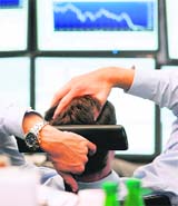 A stock trader looks at his screens at Frankfurt's stock exchange on Monday, as the DAX moved below 6,000 to 5.477,70 points, the lowest level since 2006. 