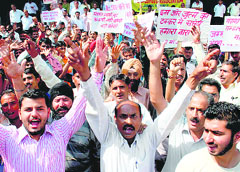 Members of the Waterworks Employees Union protest in support of their demands at BC Road in Jammu on Monday.
