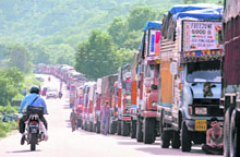 Trucks stranded on the outskirts of Jammu due to the suspension of traffic on the Jammu-Srinagar highway with the curfew in force in the Kashmir valley for the second day on Monday.