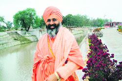 A file photo of Sant Balbir Singh Seechewal standing alongside a rejuvenated Kali Bein.