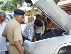 Cops investigate the car of murdered property dealer Hari Om Rana in Gurgaon on Tuesday. 