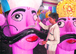 Mohammad Gyas-ud-din gives the final touches to an effigy of a demon king in Jammu.