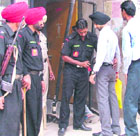 Policemen frisk visitors at court complex in Ludhiana on Tuesday.