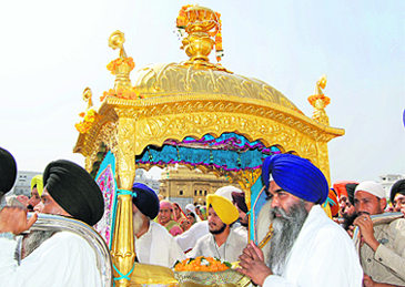 Devotees carry Guru Granth Sahib in a golden palanquin during a nagar kirtan to mark the birth anniversary of fourth Sikh master Guru Ramdas at the Golden Temple in Amritsar on Wednesday.