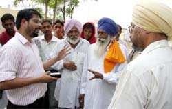 DC Rahul Tewari speaks to farmers at grain market in Bathinda