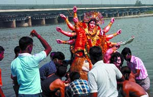 Devotees immerse an idol of Goddess Durga in river Yamuna in New Delhi 