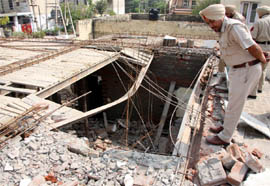 Police officials inspecting the site of the roof collapse in Model Town on Friday.