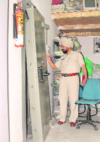 A police official inspects the strong room of the Oriental Bank of Commerce in Ludhiana. 