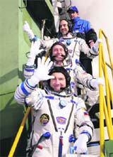 US space tourist Richard Garriott (top), US astronaut Michael Fincke (centre) and Russian cosmonaut Yury Lonchakov wave before boarding a spacecraft on Sunday. 