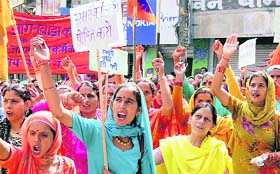 Anganwari workers raise slogans during a demonstration in support of their demands before the deputy commissioners office in Hamirpur