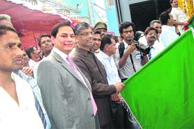 Alok Sinha, chairman and managing director, Food Corporation of India, flags off a bulk foodgrain rake in Sollu Majra village in Kaithal