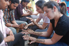 Young girls get mehndi applied on their hands in a Jalandhar market on Tuesday.