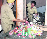 Fire workers gather crackers, stored illegally, in a house that caught fire in Ludhiana on Tuesday.