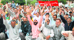 Members of the J&K Government Employees joint action committee protest in support of their demands in front of the Divisional Commissioners office in Jammu on Wednesday.